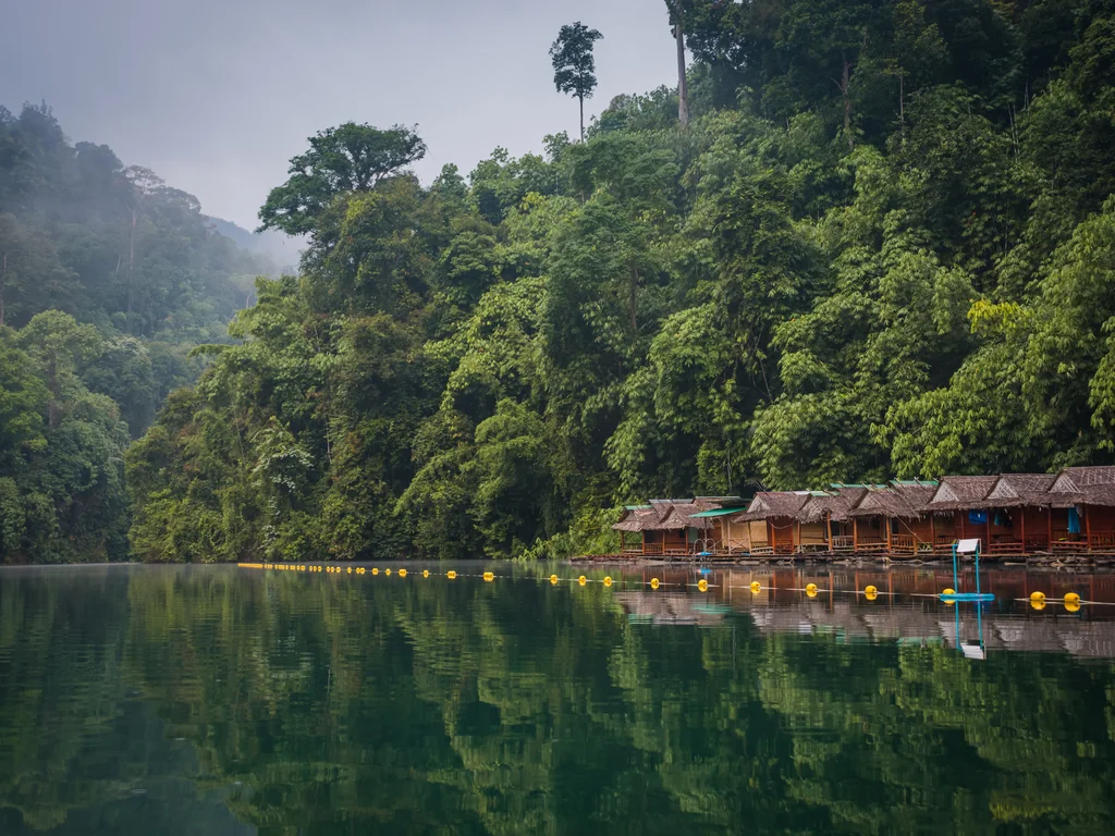 Floating raft houses beside rainforest at Khao Sok National Park