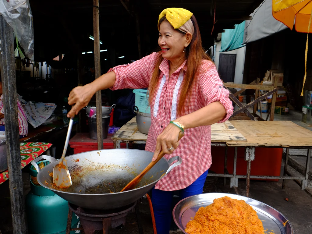 Street food vendor cooking in a wok at a Thai market