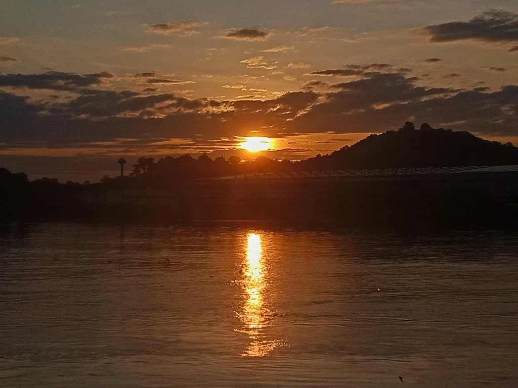 Warm sunrise light over hills and water in Thailand
